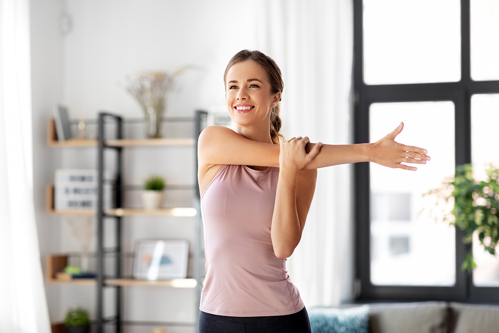 Woman stretching her arm in her living room